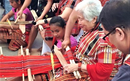<p><strong>LEARNING TO WEAVE.</strong>Department of Education Secretary Leonor Briones tries the traditional weaving of Lubuagan, Kalinga on the sidelines of the launching of the program making the traditional weaving a stand alone track for Senior High School students in Lubuagan town. The Schools division of Kalinga is positive the program will be fully implemented by school year 2020-2021. <em>(File photo courtesy of PIA-Kalinga)</em></p>