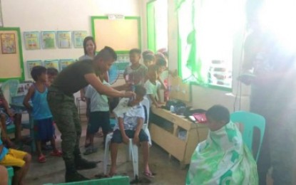 <p><strong>OUTREACH PROGRAM.</strong> Soldiers of the Army’s 33rd Infantry Battalion Battalion conduct free haircut on children as part of the outreach to the Indigenous Peoples community students in Lutayan, Sultan Kudarat on June 11, 2019. <em><strong>(Photo by Cpl. Mark Jay Kadtong - 33rd IB)</strong></em></p>