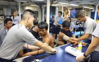 <p><strong>TREATING ABANDONED FISHERMEN. </strong>Medical crew of the Philippine Navy aboard BRP Ramon Alcaraz treat the 22 abandoned Filipino fishermen after their fishing vessel, F/B Gemver, was hit allegedly by a Chinese vessel in the waters of Recto Bank (Reed Bank) last June 9, 2019. The Philippines' Department of Foreign Affairs already filed a complaint over the latest incident. (<em>Photo courtesy of the Philippine Navy</em>)</p>