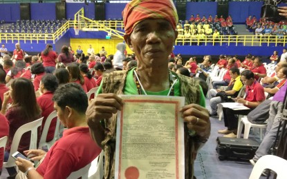 <p><strong>LAND TITLE.</strong> Tboli farmer Moda Sagan, 64, proudly shows the title for his 2.8-hectare farm in Barangay Colungulo, Surallah town in South Cotabato. President Rodrigo R. Duterte handed over land titles to over 13,500 agrarian reform beneficiaries, covering 24,000 hectares of public lands in Soccsksargen in a ceremony in General Santos City on Thursday, June 13. <em>(PNA photo by Allen V. Estabillo)    </em></p>