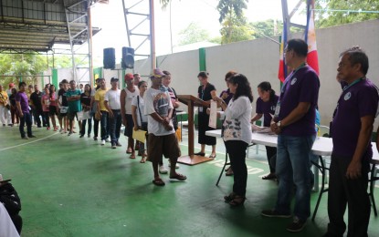 <p><strong>FREE LAND TITLES.</strong> Provincial Environment and Natural Resources Officer (PENRO) Celia Esteban (third from right) leads the distribution of land titles to 215 residents at the Cristo Rey resettlement area in Capas, Tarlac on Monday (June 17, 2019). The distribution of ownership aims to improve land administration and management and reduce poverty in rural areas. <em>(Photo courtesy of DENR-PENRO Tarlac)</em></p>