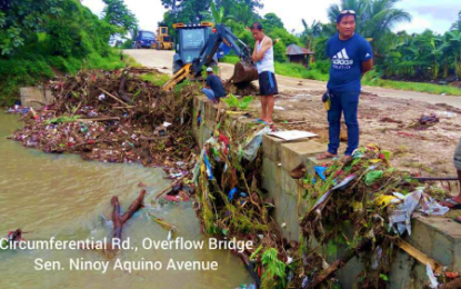 <p><strong>CLOGGED CANAL.</strong> Workers of the Kidapawan City Disaster Risk Reduction Management Office clear the debris clogging the Senator Ninoy Aquino Avenue waterway in the city proper following a heavy downpour Monday (June 17, 2019). City Mayor Joseph Evangelista appealed to his constituents not to throw garbage into creeks and rivers as these would clog waterways and cause flash floods.  <em>(Photo courtesy of Psalmer Bernalte – Kidapawan CDRRMO)</em></p>