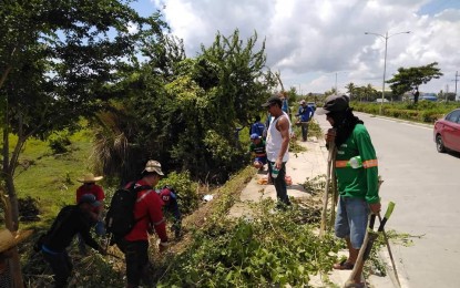 <p><strong>CITYWIDE TREE-PLANTING.</strong> The City Environment and Natural Resources Office (CENRO) is inviting stakeholders to join the citywide tree planting activity set on July 6. In the photo, personnel of the Iloilo City Agriculture Office conduct clearing operation at the Balabago Circumferential Road in preparation for the activity.  <em>(PNA photo by Iloilo City Agriculture Office)</em></p>