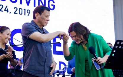 <p><strong>GESTURE OF RESPECT.</strong> Presidential photo shows President Rodrigo Roa Duterte extending his hand to his daughter Davao City Mayor Sara Duterte who showed a gesture of respect. Duterte on Thursday (June 25, 2020) signed a law restoring Good Manners and Right Conduct and Values Education as core subjects in the K to 12 curriculum in both public and private schools.<em> (File photo)</em></p>