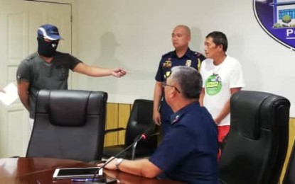 <p><strong>WRONG GUY.</strong> A masked witness points at arrested Baltazar Saldo (extreme right) as 'Virgilio Paragan', a former rebel leader facing two attempted murder charges and two murder charges. Saldo was released Monday evening (June 24, 2019) due to confusion on his real identity.<em> (PNA Photo by Gail Momblan)</em></p>