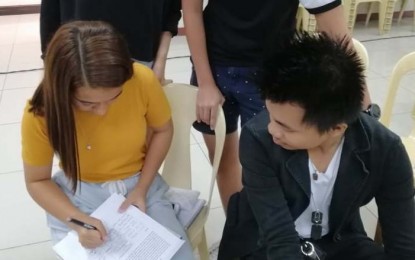 <p><strong>PETITION VS. 'RECLAMATION' PROJECT.</strong> Students sign a petition launched by environmental groups to stop the ongoing "reclamation" project at the Rizal Boulevard in Dumaguete City on Saturday (June 22, 2019). The petition, addressed to Mayor Felipe Antonio Remollo, calls for transparency on the multi-million-peso project amid a supposed Cease and Desist Order issued by the Philippine Reclamation Authority. <em>(PNA photo by Judy Flores Partlow)</em></p>
