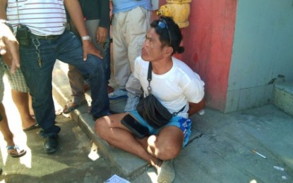 <p><strong>BUSTED MECHANIC.</strong> drug suspect Esmar Bermudes, a mechanic, squats on the pavement following his arrest Tuesday (June 25) in a drug buy-bust operation in Barangay Rosary Heights 10, Cotabato City. <em><strong>(Photo courtesy of Jome Dimapalao – Brigada News FM Cotabato)</strong></em></p>