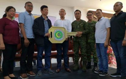 <p><strong>TURNOVER.</strong> Outgoing Maguindanao Governor Esmael Mangudadatu (4th from left) hands over the symbolic key of the provincial government to Datu Ali Sangki (3rd from left), father of Governor-elect Bai Mariam Sangki-Mangudadatu. Witnessing the event are Western Mindanao Command chief Lt. Gen. Cirilito Sobejana (4th from right) and other local officials. <em>(Photo courtesy of Jeff Mendez – DXMS Cotabato)</em></p>