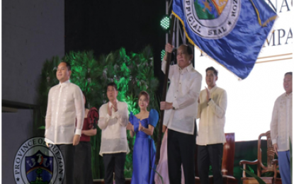 <p><strong>SCRAP IMPORTATION OF PALM OIL.</strong> Former House Minority Leader and now Quezon Gov. Danilo Danilo E. Suarez receives the provincial banner from his son outgoing Gov. David C. Suarez after their respective oath-taking and turnover of the provincial administration rites at the Quezon Convention Center, Lucena City on June 30, 2019. The Quezon governor vows to promote the coconut industry and address the plight of coconut farmers. <em>(Photo courtesy of Quezon PIO)</em></p>