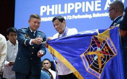 <p><strong>PAF'S 72ND ANNIVERSARY. </strong>President Rodrigo Roa Duterte attaches the streamer on the banner of one of the award-winning Philippine Air Force (PAF) units during the 72nd PAF anniversary at the Col. Jesus Villamor Air Base in Pasay City on Tuesday (July 2, 2019). Assisting the President is PAF Commander Lieutenant General Rozzano Briguez. <em>(Karl Norman Alonzo/Presidential Photo)</em></p>