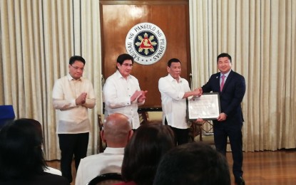 <p><strong>THIRD TELCO</strong>. President Rodrigo Duterte awards the permit to operate the country’s third telecommunication firm to Dennis Uy of Mislatel Consortium at Malacañan Palace on Monday (July 8, 2019). National Telecommunications Commissioner Gamaliel Cordoba (left) and Information and Communications Technology Secretary Gringo Honasan (2nd from left) witnessed the awarding ceremony. <em>(PNA photo by Azer Parrocha)</em></p>