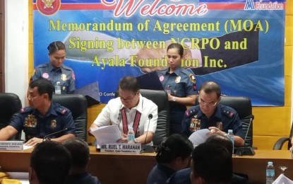 <p><strong>PULIS MAGITING PROGRAM</strong>. National Capital Region Police Office chief Maj. Gen. Guillermo Eleazar (right) and Ayala Foundation president Raul Maranan (middle) sign the memorandum of agreement for the implementation of the Pulis Magiting Program.<em> (Photo by Christopher Lloyd Caliwan) </em></p>