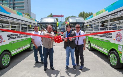 <p><strong>MODERN TRANSPORT.</strong> Secretary Michael Lloyd Dino (right), head of the Office of the Presidential Assistant for the Visayas, and Land Transportation Franchising and Regulatory Board Regional Director Edgardo Montealto cut the ceremonial ribbon to mark the roll-out of the 298 modern public utility vehicles (PUVs) in Cebu City on Thursday (July 11, 2019). Dino said the launching of the 'golden age' of the transportation system in Cebu has materialized after President Rodrigo Duterte's promise in his third state of the nation address (SONA) last year to modernize PUV operations in the Philippines. <em>(Photo courtesy of OPAV)</em></p>