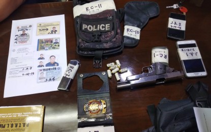 <p><strong>SEIZED FROM FAKE COP.</strong> Police operatives confiscated from Robel Canlas a PNP bag which contained a .45-caliber handgun with six bullets, a fake PNP ID and badge. The suspect will face charges of usurpation of authority, estafa, and illegal possession of firearms. <em>(Photo courtesy of PNP)</em></p>