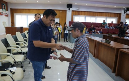 <p><strong>FINANCIAL AID.</strong> South Cotabato Governor Reyanaldo Tamayo Jr. (left) hands over a check to one of the recipients of the Enhanced Comprehensive Local Integration Program or E-CLIP in a ceremony at the provincial capitol on Tuesday (July 16, 2019). Some 33 former rebels from different parts of South Cotabato province received a total of PHP1.97 million worth of financial assistance under the reintegration program. <em>(PNA photo by Allen V. Estabillo)</em></p>