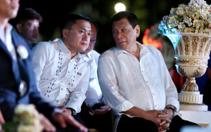 <p><strong>GO-DUTERTE TANDEM</strong>. President Rodrigo Duterte chats with Senator Christopher “Bong” Go (left) in this undated file photo. A Pulse Asia survey held from February 10 to 19 showed that the possible Go-Duterte tandem in the 2022 presidential election got the highest 32 percent preference. <em>(PNA file photo)</em></p>