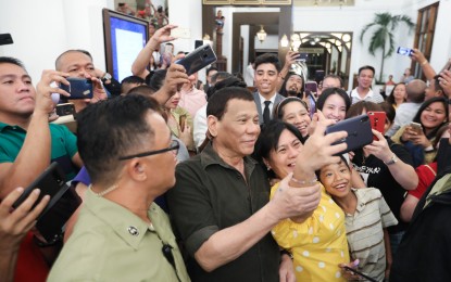<p>People flock towards President Rodrigo Duterte to have a groufie. (<em>PNA File photo)</em></p>