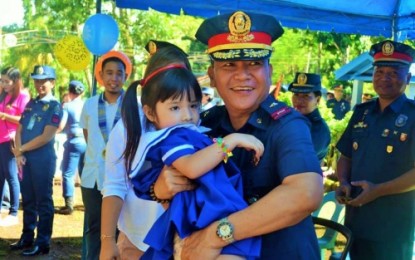 <p><strong>KID-FRIENDLY CAMP.</strong> Brigadier General Marni Marcos Jr, director of the Police Regional Office–Bangsamoro Autonomous Region in Muslim Mindanao (PRO-BARMM), carries a student of the PRO-BARMM Kindergarten School inside Camp Salipada. K. Pendatun in Parang, Maguindanao, following the ceremonial opening of the school’s playground on Sunday (July 28, 2019). <em>(Photo courtesy of PRO-BARMM)</em></p>
