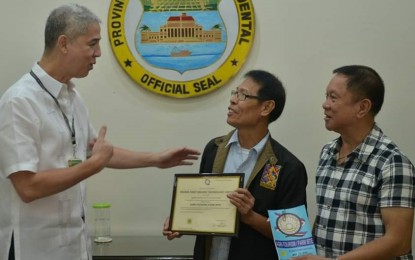 <p><strong>ACCREDITATION.</strong> Department of Tourism-Western Visayas Regional Administrative Officer Artemio Ticar (center) presents to Governor Eugenio Jose Lacson (left) the accreditation certificate granted to the Negros First Organic Technology Center as a farm tourism site, in the presence of Provincial Agriculturist Japhet Masculino (right). The presentation was done at the Provincial Capitol in Bacolod City on Friday (July 26, 2019).<em> (Photo courtesy of PIO-Negros Occidental)</em></p>