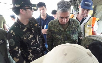 <p><strong>SEARCH AND RESCUE.</strong> Lt. Col. Jose Mari F. Torrenueva II (right, in combat uniform), commander of the 91st Infantry “Sinagtala” Battalion, Philippine Army, looks at the map being used to search for a missing training aircraft at the tactical command post of the 91IB in Maria Aurora town, Aurora province on Monday, July 29, 2019. The missing aircraft, C-152, RPC 3604, was piloted by Aaron Dizon.<em> (Photo by Jason De Asis)</em></p>