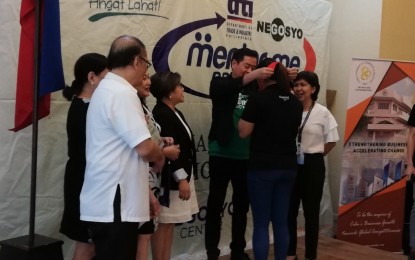 <p><strong>BUDDING ENTREPRENEURS.</strong> Cebu Chamber of Commerce and Industry Vice President Jay Yuvallos awards the graduation medal to one of the 25 micro, small, and medium entrepreneurs who finished the "Kapatid Mentor Me" Program of the Department of Trade and Industry in a simple ceremony at Aiza Suites in Cebu City on Wednesday (July 31, 2019). Also in photo are DTI-7 Regional Director Asteria Caberte (fourth from left), DTI-Cebu Officer in Charge Esperanza Melgar (right), and the mentors of the program.<em> (Photo by John Rey Saavedra)</em></p>
