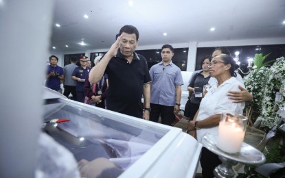 <p><strong>LAST RESPECTS</strong>. President Rodrigo Roa Duterte pays his last respects to one of the slain police officers as he visits the wake at Camp Lt. Col. Francisco C. Fernandez Jr. in Sibulan, Negros Oriental on July 20, 2019. During his visit, the President honors the four police officers who were killed in an ambush by suspected communist rebels last July 18. <em>(Presidential Photo)</em></p>