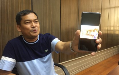 <p><strong>HOUSING PROJECT.</strong> Governor Edwin Jubahib shows to members of the media a photo of him with the Indigenous Peoples whom he said are situated in the farthest part of Davao del Norte, on Saturday (Aug. 3, 2019). Jubahib also discussed his plans for the IP communities which include housing projects, water systems, access roads, and livelihood projects. <em>(PNA Photo by Che Palicte)</em></p>