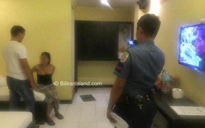 <p><strong>HOTEL RAID.</strong> Police operatives raid a hotel room in Naval, Biliran where a live-in couple brought two 14-year-old boys, whom the female suspect offered for online sexual exploitation in exchange for money on Tuesday noon (August 6, 2019). The 18-year-old female suspect and her live-in partner, 28, will be charged with violating the Anti-Trafficking in Persons Act. <em> (Photo from Biliran Island FB page)</em></p>
