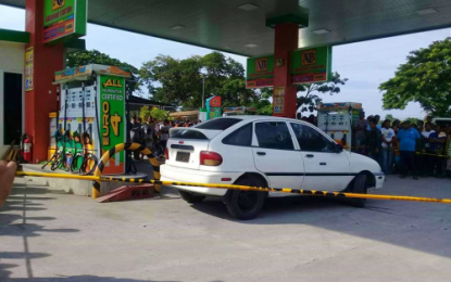 <p><strong>SEALED OFF.</strong> Police probers cordoned off the Kia sedan of alleged Moro Islamic Liberation Front field commander Sangutin Musil and hos companion Alex Amino Toto who were both gunned down at a gas station by two gunmen onboard a motorbike in Tacurong City, Sultan Kudarat, on Tuesday (Aug. 6, 2019). <em>(Photo courtesy MAX FM Tacurong)</em></p>