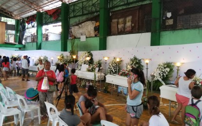 <p><strong>LESSON LEARNED.</strong> Residents of Ermita village in Cebu City flock to the gymnasium where the remains of seven of their nine neighbors who died in a sea tragedy in Iloilo lie at a wake, as the city and village officials arrange for their burial on Sunday (August 11, 2019). Mayor Edgardo Labella said the fate of his nine constituents should serve as a 'lesson learned' and a basis to craft stricter rules on sea transport.<em> (PNA photo by John Rey Saavedra)</em></p>