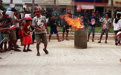 <p><strong>NO TO NPAs.</strong> Residents of San Isidro, Leyte burn the flags of the Communist Party of the Philippines-New People's Army-National Democratic Front during a peace rally on August 5 condemning the atrocities of the rebel group. <em>(Photo from the FB page of Technical Education and Skills Development Authority) </em></p>