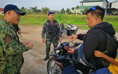 <p><br /><strong>VEHICLE CHECK.</strong> Police officers check on registration documents of a motorist during the implementation of “Oplan Lambat Bitag in Carmen, North Cotabato on Saturday (Aug. 10, 20190.<em> (Photo courtesy of Carmen MPS)</em></p>
