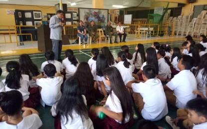 <p><strong>LOCAL HEROES.</strong> Ray Kimilat (left, standing), head of teaching operations of the Abellana National School in Cebu City, talks to high school students about the significance of studying the lives of local heroes, during the opening program of Central Command's local heroes exbibit at the Cebu Youth Center at the school campus on Tuesday, Aug. 13, 2019. Also in photo are school personnel and soldiers from the 3rd Civil Relations Group and Central Command. <em>(Photo contributed by Staff Sgt. Joy dela Peña)</em></p>