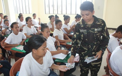 <p><strong>DECEPTION.</strong> A young soldier distributes reading materials illustrating the deception strategies of communist rebels. The Philippine Army has been raising awareness among students to save them from recruitment activities of communist rebels and their supporters. <em>(Photo courtesy of 14th Infantry Battalion)</em></p>