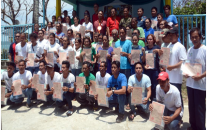 <p><strong>FROM LAND TILLERS TO LANDOWNERS.</strong> Department of Agrarian Reform (DAR)-Calabarzon Regional Director Rene Colocar (standing center, 3rd row with lei) joins some 50 former coconut farmers who are now land owners as they flashed their Certificates of Land Ownership Award (CLOAs) during the simple distribution rite in San Francisco, Quezon on Wednesday (Aug. 14, 2019). Each farmer received a CLOA from the 120.5 hectares of land from the properties of the Matias clan--Mario, Michael and Moises-- in Barangays Silongin and Casay in the town. <strong><em>(Photo courtesy of DAR-PAMRS)</em></strong></p>