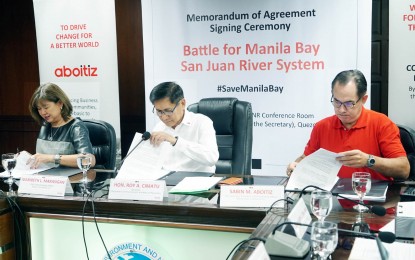 <p><strong>SAN JUAN RIVER CLEAN UP DRIVE</strong>. Photo shows DENR Secretary Roy A. Cimatu (center), Sabin M. Aboitiz (right), Executive Vice President and Chief operating Officer of Aboitiz Equity Ventures; and Maribeth L. Marasigan (left), Chief Operating Officer of Aboitiz Foundation; sign the memorandum of agreement (MOA) for the rehabilitation of the San Juan River held at the DENR office in Quezon City on Friday (Aug. 16, 2019). The San Juan River rehabilitation involves the development and implementation of a comprehensive program intended to reduce the pollution in its river system. (<em>PNA photo by Ben Briones</em>)</p>
