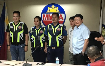 <p><strong>NEW VESTS</strong>. MMDA Chairman Danilo Lim (right), Alvin Carranza (2nd from right), CEO of advertising company MacGraphics Carranz, Inc., and MMDA EDSA Special Traffic and Transport Zone head Edison “Bong” Nebrija take a photo with MMDA enforcers wearing the new high-visibility reflective vests at the MMDA office in Makati City on August 16, 2019.<em> (Photo by Raymond Carl Dela Cruz)</em></p>