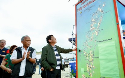 <p><strong>SOLAR POWER</strong>. President Rodrigo Roa Duterte inspects the map of the areas to be powered by the Tumingad Solar Power Project as he leads its inauguration in Odiongan, Romblon on August 21, 2019. With the President is Energy Secretary Alfonso Cusi.<em> (Richard Madelo/Presidential Photo)</em></p>