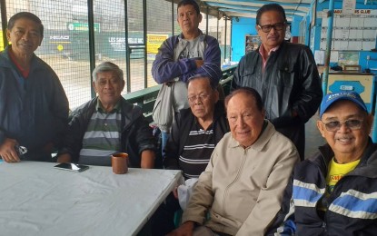 <p><strong>TENNIS LOVERS</strong>. Members and past officers of the Baguio Tennis Club (BTC) within the Baguio athletic bowl complex at Burnham park have high hopes that they can continue playing tennis, the only physical activity they enjoy doing and can afford as retired persons. The BTC was founded in 1976 after the city through an ordinance, gave the administration of the facility at the behest of prominent Baguio residents including retired Baguio General Hospital director Dr. Jesus del Prado (2nd from right, sitting), 88 years old. Also in photo at the court facility on a rainy Friday are (L-R, sitting) Jess Castillo, 73; Claro Ramollete, 86; Jesus del Prado, 88; Alex Rodriguez, 73; (L-R, standing) Rolando de Guzman, 69, an unidentified hanger on and Tony Domes-ag, 66. <em>(PNA photo by Pigeon Lobien)</em></p>