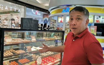 <p><strong>DABAWENYO CHOCO.</strong> Rex Victor Puentispina, Malagos Agri Venture Corporation sales and marketing director, shows the some of the internationally-recognized chocolate proucts  they sell in their store at SM City Davao. <em>(Photo by Digna Banzon)</em></p>