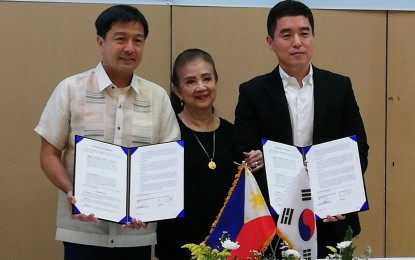 <p><strong>MOA SIGNING.</strong> Landowner Ma. Teresa Lacson (center) with Amatera Renewable Energy Corp. chief finance officer Ramon Luis Lacson (left) and TPC Construction Corp. president Charles Ji after the signing of the memorandum of agreement for the development of the 50-megawatt solar power plant in Barangay Vista Alegre, Bacolod City, in a ceremony held at L’ Fisher Chalet on Friday night (September 6, 2019). Amatera is leasing the 74-hectare Lacson family land for 25 years to the Korean firm for the first-ever large-scale solar power project in Bacolod. (<em>PNA photo by Nanette L. Guadalquiver)</em></p>