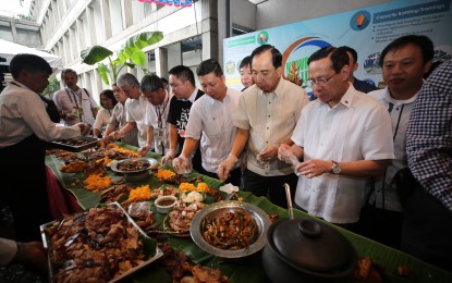<p><strong>PORK CHALLENGE</strong>. Agriculture Secretary William Dar (3rd right), Health Secretary Francisco Duque (2nd right), and members of the hog industry hold a boodle fight at the Bureau of Soils and Water Management in Quezon City on Monday (Sept. 9, 2019) to show to the public that it is safe to eat pork provided it underwent sanitary and phytosanitary procedure from the National Meat Inspection System.  The DA confirmed it was African swine fever that prompted the depopulation of more than 7,000 hogs in Bulacan and Rizal farms last month. (<em>Photo courtesy of DA</em>)</p>