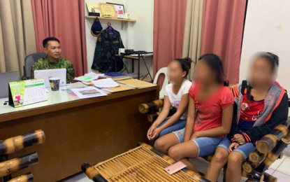 <p><strong>RESCUED</strong>. Lt. Col. Ibrahim Jambiran, chief of police of Parang, Maguindanao, speaks to the three minors rescued from suspected human traffickers during a police enforcement operation conducted on Saturday (Sept. 14, 2019). The suspects are now detained at the Parang police station.<em> (Photo courtesy of Parang MPS)</em></p>