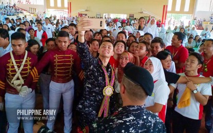 <p><strong>INSPIRING THE YOUTH. </strong>Screen actor and Philippine Army (PA) reservist, 2nd Lt. Matteo Guidicelli, takes a selfie with students of the Basilan State College, on the sidelines of a forum on Tuesday (Sept. 17, 2019). Guidicelli encouraged the attendees of the forum to use their potentials to serve and showcase the beauty of Basilan to counter the negative perception about the island province. <em>(Photo courtesy: Office of the Army Chief Public Affairs)</em></p>