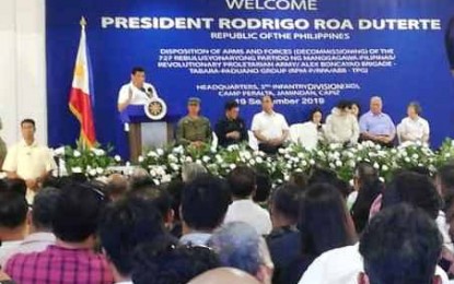 <p><strong>REINTEGRATION.</strong> President Rodrigo R. Duterte urges the 727 members of the Rebolusyonaryong Partido ng Manggagawa-Pilipinas -- Revolutionary Proletarian Army -- Alex Boncayao Brigade – Tabara-Paduano Group to live productive lives with their loved ones. Duterte witnessed the ceremonial disposition of firearms that were surrendered by the group at Camp General Macario B. Peralta, Jr. in Jamindan, Capiz on Thursday (Sept. 19, 2019). <em>(PNA photo by Gail Momblan)</em></p>