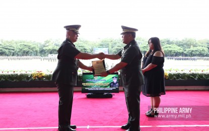 <p><strong>FAREWELL.</strong> Philippine Army chief, Lt. Gen. Macairog S. Alberto, hands over a plaque of recognition to outgoing Armed Forces of the Philippines Chief of Staff, Gen. Benjamin Madrigal Jr., during a testimonial parade and review at the Army headquarters in Fort Bonifacio, Taguig City on Friday (Sept. 20, 2019). Madrigal will bow out of the service upon reaching the mandatory retirement age of 56 on September 28. <em>(Photo courtesy of the Office of the Army Chief Public Affairs)</em></p>