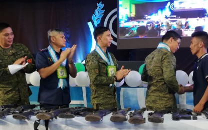 <p><strong>RETURN TO THE FOLD.</strong> Army officials (from left) Lt. Col. Emelito Thaddeus Logan, commander of 79th Infantry Battalion; Col. Romeo Baleros, director of Negros Occidental Police Provincial Office; Brig. Gen. Benedict Arevalo, commander of 303rd Infantry Brigade, applaud the surrender of a firearm of former communist rebel 'Ka Joros' to Brig. Gen. Eric Vinoya (2nd from right), commander of Joint Task Force-Negros, during the North Negros Peace Summit in Escalante City on Friday (Sept. 20, 2019). Vinoya said they aim to dismantle the NPA’s northern and central Negros fronts by the end of 2019. <em>(PNA photo by Nanette L. Guadalquiver)</em></p>