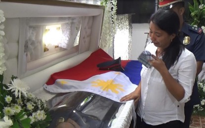 <p><strong>SLAIN COP.</strong> Michelle Gumarang, wife of slain Staff Sergeant Richard Gumarang, weeps in front of the coffin bearing the remains of her husband at the Isabela provincial police office on Monday (Sept. 22, 2019). Gumarang was killed in a shootout with four robbers in Ramon, Isabela on Friday last week. <em>(PNA photo by Villamor  Visaya Jr.)</em></p>