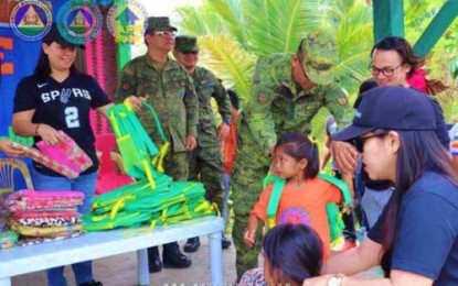 <p><strong>REACHING OUT.</strong> Soldiers and non-government organization workers distribute school bags to pupils of the S. Midal Elementary School in Barangay Tinungkaan, Upi, Maguindanao, during an outreach program on Tuesday (Sept. 24, 2019). A similar activity was also held at the Kibleg Elementary School in Barangay Kibleg of the same town where schoolchildren were given 350 sets of dental kits and slippers, among others.<em> (Photo courtesy of 6ID)</em></p>