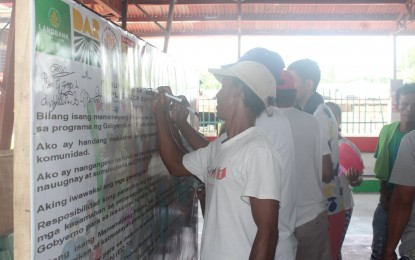 <p><strong>COMMITMENT VS. TERRORISM.</strong> Former members of the Alyansa ng Manggagawang Bukid sa Hacienda Luisita (AMBALA) sign a pledge of commitment against terrorism during a peace forum held in Barangay Balete, Hacienda Luisita in Tarlac on Wednesday (Sept. 25, 2019). AMBALA is known for its alliance with the Communist Party of the Philippines-New People’s Army that capitalizes on the non-distribution of lands in the sugar plantation in order to recruit members and stage mass actions against the government. <em>(Photo from 1st Civil Relations Group, CRS-AFP)</em></p>